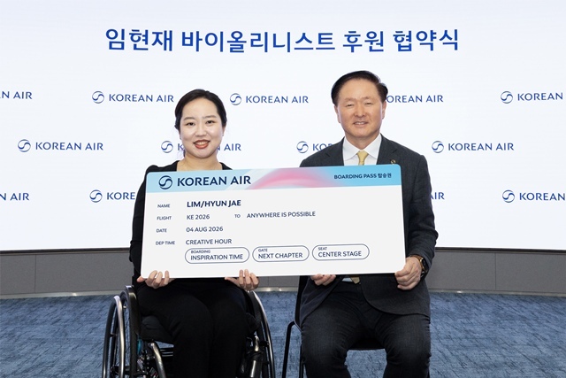 우기홍 대한항공 부회장(오른쪽)과 바이올리니스트 임현재가 후원 협약식에서 모형 항공권을 들고 기념촬영을 하고 있다. /대한항공