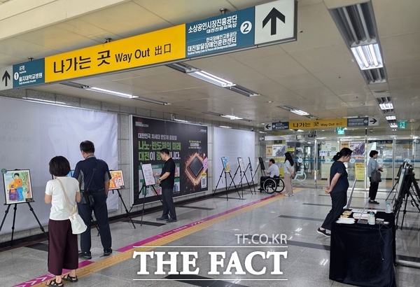 대전시 서구는 10일부터 14일까지 정부청사역 대합실에서 제13회 대전 장애인 백일장 및 사생대회 수상작 전시회 '누군가의 마음을 보셨나요?'를 열었다. 정부청사역 이용객들이 제13회 장애인 백일장 및 사생대회 수상작들을 감상하고 있다. /대전시 서구