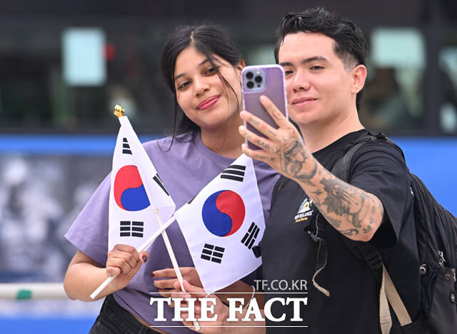 서울 종로구 보신각을 찾은 외국인 관광객들이 무료 나눔으로 받은 태극기와 기념촬영하고 있다.