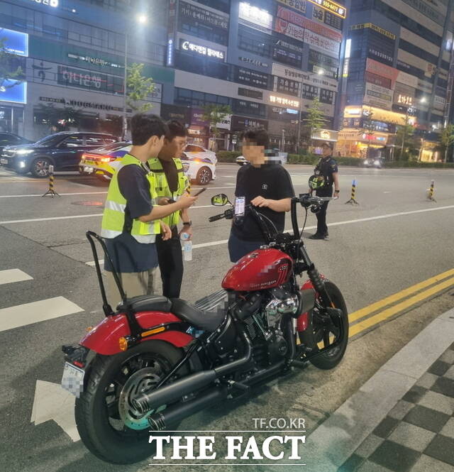 광복절 합동 단속 현장에서 시청과 경찰 합동단속반이 오토바이 운전자의 불법 개조 여부를 점검하고 있다. /정효기 기자
