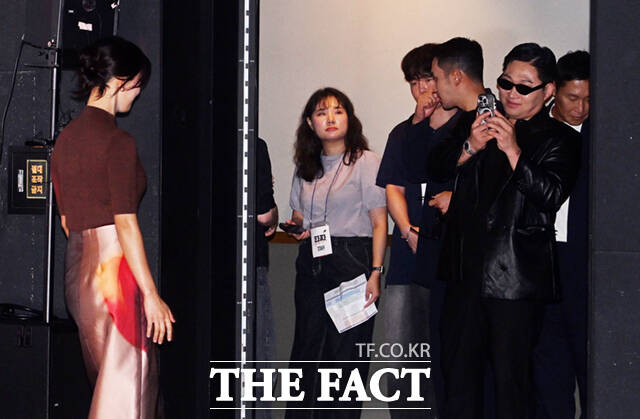 배우로 데뷔한 스윙스가 영화 '타짜: 벨제붑의 노래' 제작보고회에 참석해 동료 배우들의 모습을 자신의 휴대전화에 담고 있다.