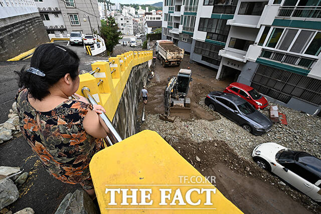 경상남도 거제시를 중심으로 기록적인 폭우가 내린 가운데 18일 오후 경남 거제시 거제대로 인근 아파트 인근의 한 주민이 수해 복구 작업을 바라보고 있다. /거제=김성렬 기자
