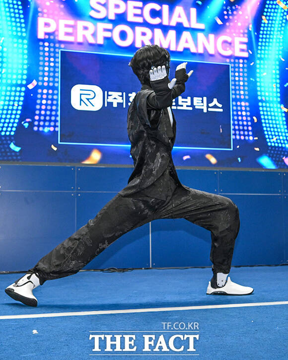 관람객이 아고라 부스에서 대화형 AI 로봇을 살펴보고 있다.