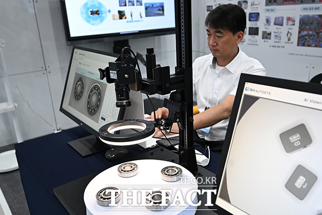 관람객이 아고라 부스에서 대화형 AI 로봇을 살펴보고 있다.