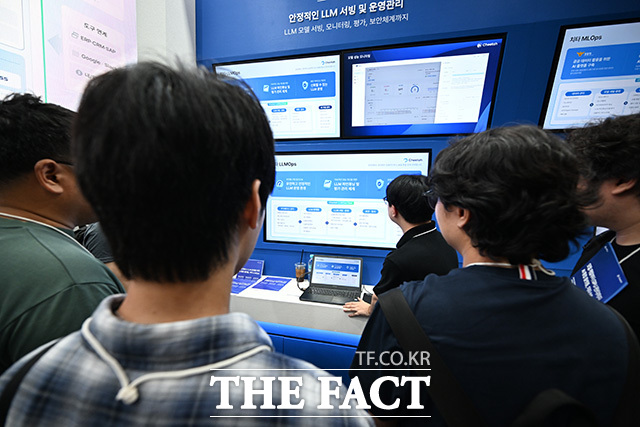 관람객이 아고라 부스에서 대화형 AI 로봇을 살펴보고 있다.