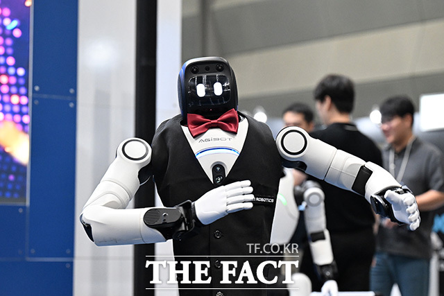 관람객이 아고라 부스에서 대화형 AI 로봇을 살펴보고 있다.