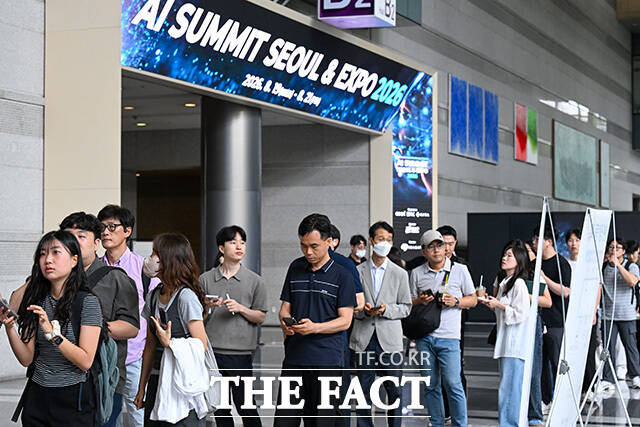 관람객이 아고라 부스에서 대화형 AI 로봇을 살펴보고 있다.