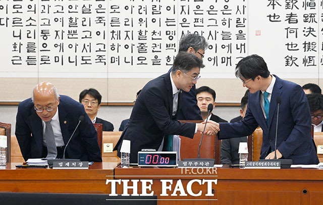 이진수 법무부 차관(가운데)이 법제사법위원회 전체회의에 출석해 오동운 고위공직자범죄수사처장과 인사를 나누고 있다.