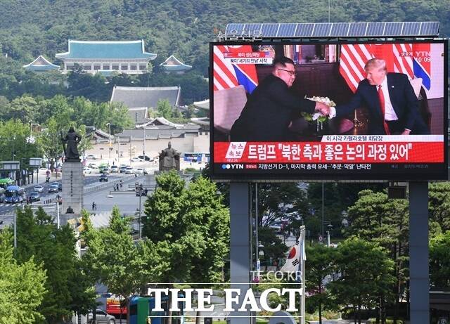 도널드 트럼프 미국 대통령(오른쪽)이 북미 정상회담 개최 의지를 내비치고 있다. 사진은 김정은 북한 국무위원장과 트럼프 미국 대통령이 2018년 6월 12일 싱가포르 한 호텔에서 정전 65년 만에 열린 북미정상회담에서 악수하는 모습. 서울 세종대로의 대형 화면 뒤로 청와대의 모습이 보인다. /배정한 기자