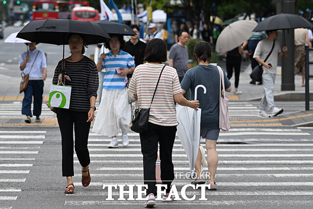 22일 오전 서울 종로구 광화문광장 일대에서 시민들이 우산을 쓰거나 쓰지 않고 거리를 걷고 있다. /박헌우 기자