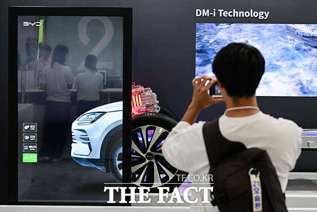 한 관람객이 'EV 트렌드 코리아 2026' BYD 부스에서 DM-i 기술 전시를 촬영하고 있다.