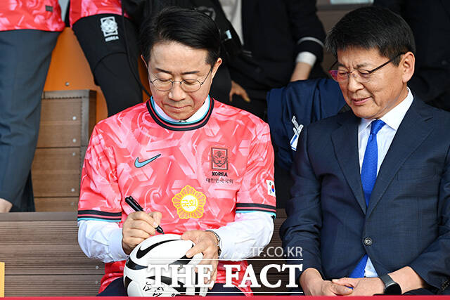축구공에 사인하는 조정식 국회의장(왼쪽).
