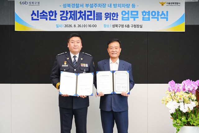 이승로 성북구청장(오른쪽)과 김정완 성북경찰서장이 지난 26일 성북구청에서 성북경찰서 부설주차장 내 무단 방치 차량 및 장기 주차위반 차량 등의 강제처리를 위한 업무협약을 체결하고 기념촬영을 하고 있다. /성북구