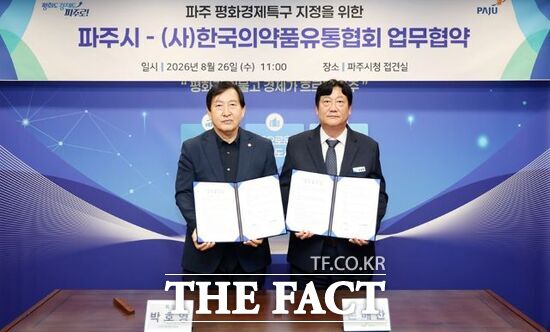 26일 박호영 한국의약품유통협회장과 손배찬 경기 파주시장(오른쪽)이 '파주 평화경제특구 의약품 유통산업 발전을 위한 업무협약'을 체결한 뒤 협약서를 들어 보이고 있다. /파주시