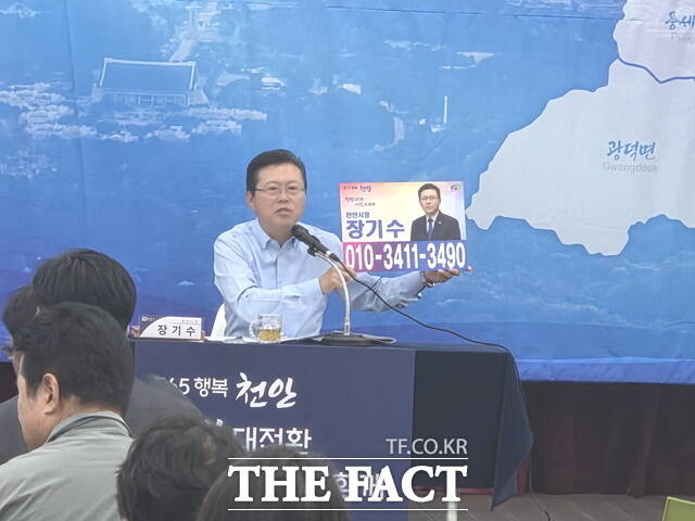 장기수 천안시장이 26일 광덕문화센터에서 열린 순회 간담회에서 자신의 휴대전화 번호를 공개하며 주민들과 소통하고 있다. /정효기 기자