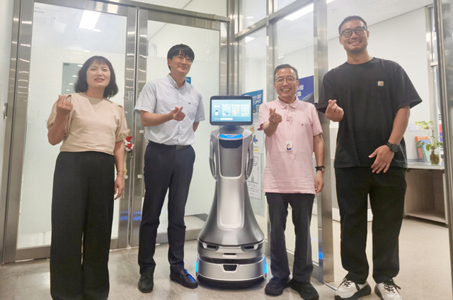 국립울진해양과학관이 도입한 인공지능(AI) 안내로봇 ‘코스미’와 기념사진을 찍고있다. /해양과학관