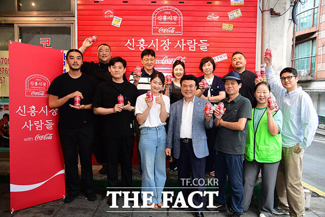 지난 1일 전시 '신흥시장 사람들 with 코카-콜라' 개최를 기념해 신흥시장 상인들이 서울 용산구 해방촌 신흥시장 초입에서 기념 촬영을 하고 있다.