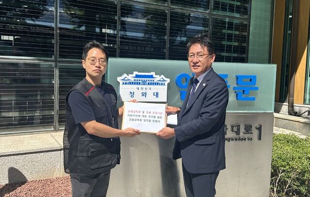 김상우 금감원 노조위원장(왼쪽부터)이 4일 오후 청와대에서 배진교 청와대 국민경청비서관에게 금감원 등 금융 공공기관의 지방이전을 반대하는 탄원서를 제출하고 있다. /금감원 노조