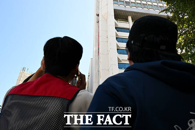 양규서 민주노총 공공운소노조 조직국장이 자신과 아내에 대한 징계·해고에 항의하며 7일 오전 서울 중구 경향신문사 빌딩 외벽에서 몸을 밧줄에 묶어 매달리는 고공 시위를 하고 있다. /박상민 기자