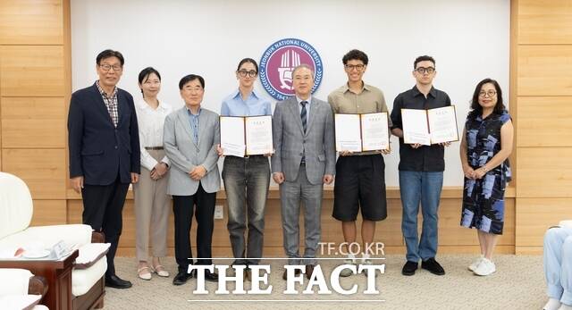 8일 전북대학교 총장실 접견실에서 양오봉 총장(가운데)이 베네수엘라 유학생들에게 특별장학증서를 전달하고 관계자들과 기념 촬영을 하고 있다. /전북대