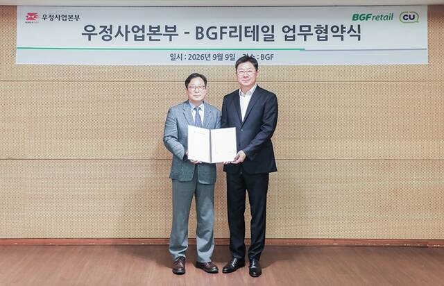 지난 9일 서울 강남구 BGF그룹 사옥에서 민승배 BGF리테일 대표(오른쪽), 박인환 우정사업본부 본부장(왼쪽)이 BGF리테일과 우정사업본부의 업무협약식에서 기념 촬영을 하고 있다. /BGF리테일
