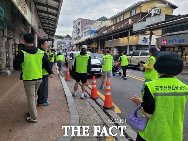공주산성시장상인회가 10일 산성시장 용당길 일원에서 '주·정차 홀짝제' 홍보 등 직접 교통질서 잡기에 나섰다. /공주시