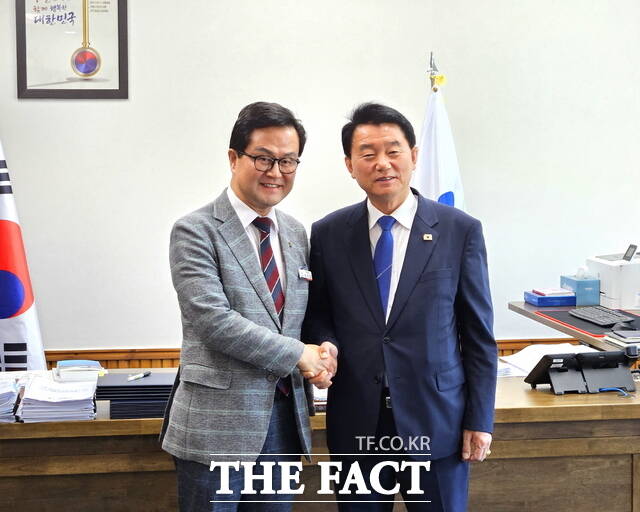 11일 서천군청에서 유승광 서천군수(오른쪽)와 엄승용 보령시장이 악수하며 기념 촬영을 하고 있다. /서천군