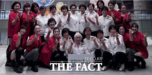 제19회 대구시 주민자치 프로그램 경연대회에 군위군 대표로 출전한 군위읍 군위흥바람댄스팀(빨간색 의상)과 우보면 군위우보예술단(흰색 의상)이 경연을 마친 뒤 손하트와 함께 환하게 웃으며 기념 촬영을 하고 있다. /군위군