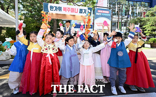 '2026 추석맞이 강남구 직거래장터'가 16일 오전 서울 강남구 강남구청 주차장에서 열린 가운데 한복을 입은 어린이들이 사과를 시식하고 있다. /박상민 기자
