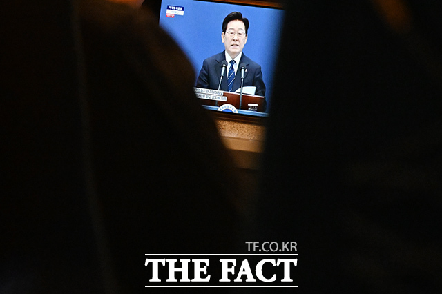 이재명 대통령이 18일 오전 청와대 영빈관에서 기자회견을 연 가운데, 시민들이 열차 안에서 기자회견을 시청하고 있다. /김성렬 기자