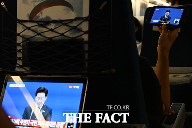 이재명 대통령이 18일 오전 청와대 영빈관에서 기자회견을 연 가운데, 시민들이 열차 안에서 기자회견을 시청하고 있다. /김성렬 기자
