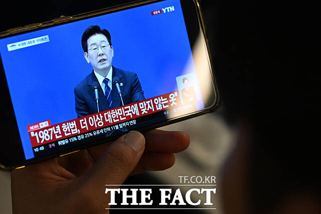 이재명 대통령이 18일 오전 청와대 영빈관에서 기자회견을 연 가운데, 시민들이 열차 안에서 기자회견을 시청하고 있다. /김성렬 기자
