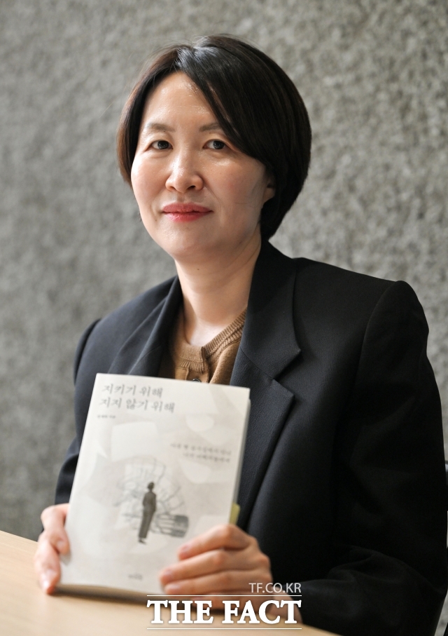 김세희 변호사가 9일 오후 서울 종로구 광화문 카페게더에서 <더팩트>와 인터뷰에 앞서 저서 '지키기 위해 지지 않기 위해'를 들고 포즈를 취하고 있다. /서예원 기자