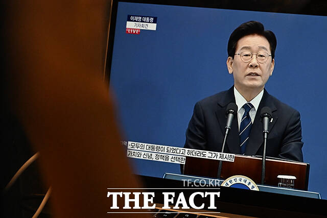 이재명 대통령이 18일 오전 청와대 영빈관에서 기자회견을 연 가운데, 시민들이 열차 안에서 기자회견을 시청하고 있다. /김성렬 기자