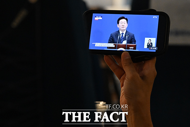 이재명 대통령이 18일 오전 청와대 영빈관에서 기자회견을 연 가운데, 시민들이 열차 안에서 기자회견을 시청하고 있다. /김성렬 기자