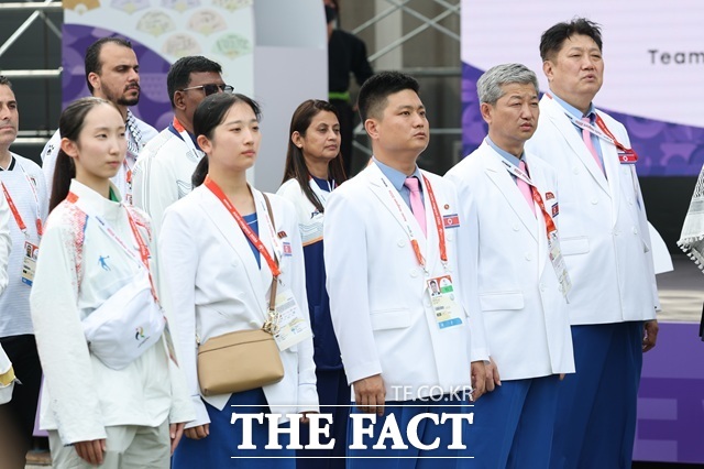 북한이 2026 아이치·나고야 아시안게임 개회식에서 탁구 우태룡과 복싱 황효순을 기수로 앞세워 8번째로 입장한다. 사진은 박천종 선수단장을 비롯한 북한 선수단이 지난 18일 오후 일본 나고야향 인근에 마련된 2026 아이치·나고야 아시안게임 선수촌에서 열린 입촌식에서 인공기 게양을 바라보고 있는 모습. /나고야=뉴시스