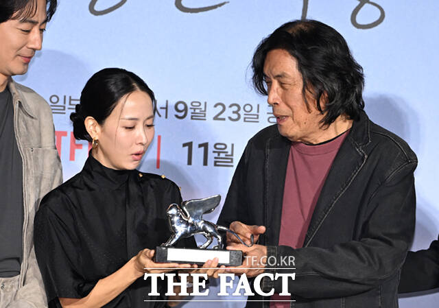 21일 서울 용산구 CGV 용산 아이파크몰에서 영화 '가능한 사랑' 언론시사회 및 기자간담회가 열린 가운데, 이창동 감독이 제83회 베네치아국제영화제에서 수상한 은사자상(심사위원 대상)을 출연 배우 조여정에게 건네고 있다. /이새롬 기자