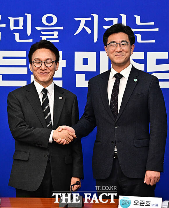 김민석 더불어민주당 대표(왼쪽)가 21일 오후 서울 여의도 국회에서 오준호 기본소득당 대표를 접견하며 취임 축하 난을 선물하고 있다. /국회=배정한 기자