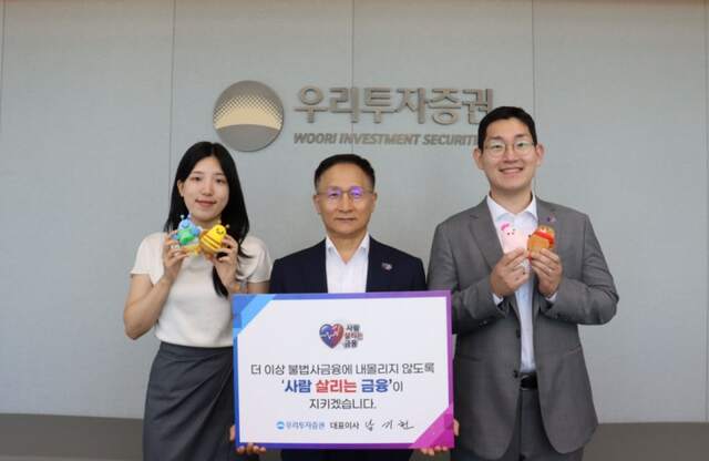 남기천 우리투자증권 대표(가운데)가 사내 주니어 혁신조직 우투리(우리투자리더스) 직원들과 함께 사람 살리는 금융 캠페인에 참여하고 기념 촬영하고 있다. /우리투자증권