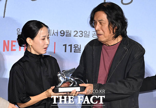21일 서울 용산구 CGV 용산 아이파크몰에서 영화 '가능한 사랑' 언론시사회 및 기자간담회가 열린 가운데, 이창동 감독이 제83회 베네치아국제영화제에서 수상한 은사자상(심사위원 대상)을 출연 배우 조여정에게 건네고 있다. /이새롬 기자