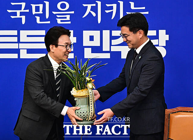 김민석 더불어민주당 대표(왼쪽)가 21일 오후 서울 여의도 국회에서 오준호 기본소득당 대표를 접견하며 취임 축하 난을 선물하고 있다. /국회=배정한 기자