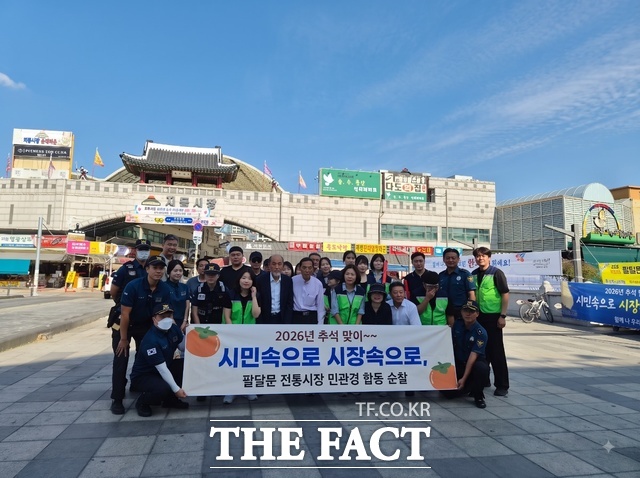 수원팔달경찰서 경찰관과 상인, 주민 등 민·관·경 합동순찰 참가자들이 22일 수원 팔달문 앞에서 추석 명절 안전을 위한 순찰에 앞서 기념 촬영을 하고 있다. /수원팔달경찰서