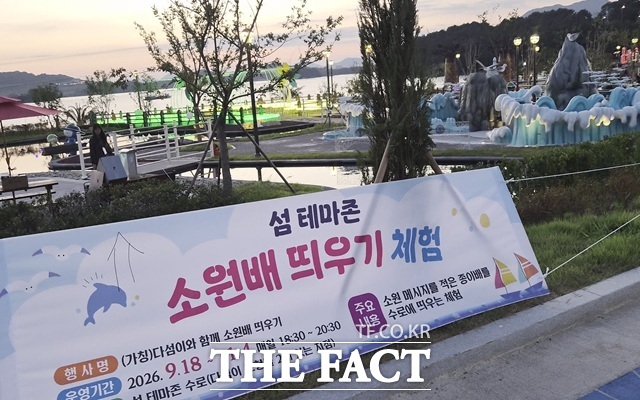 21일 저녁 여수 세계 섬 박람회 현장에서 플래카드를 걸고 소원배 띄우기 체험을 홍보하고 있다. 종이배에 소원을 적은 뒤 수로에 띄우는 체험이다. /여수=오승혁 기자