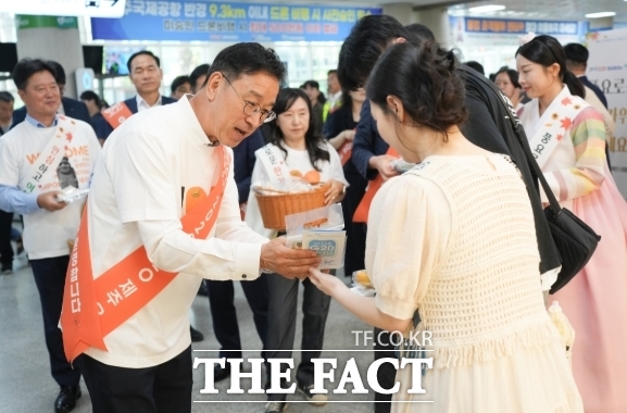위성곤 제주도지사가 제주를 찾은 관광객들에게 기념품을 전달하며 2028년 20개국 정상회의 제주 유치를 알리고 있다. /제주도