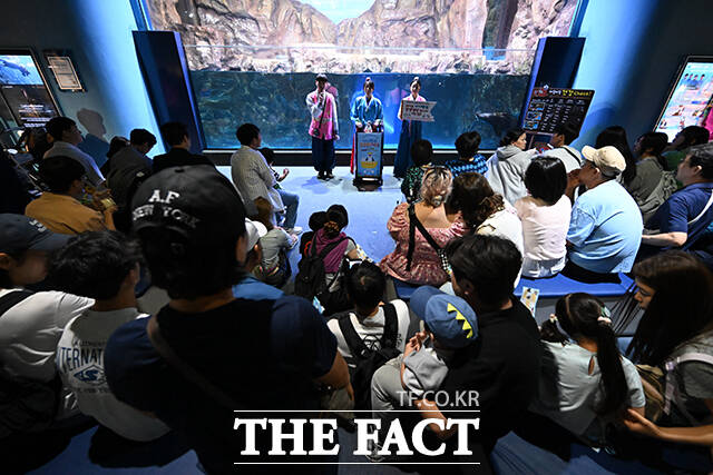 추석 연휴를 맞아 나들이 나온 시민들이 건강검진을 받는 아기펭귄을 관람하고 있다.