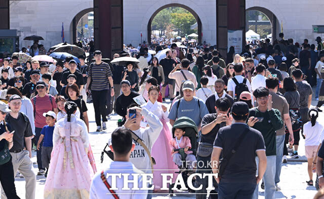 26일 서울 종로구 광화문 앞을 찾은 시민들과 관광객들이 수문장 파수의식을 관람하고 있다.