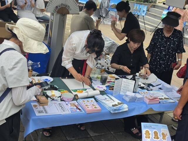 주민과 관광객들이 독도 관련 퀴즈를 풀고 캘리그라피 체험행사에 참여하고 있다./ 울릉군