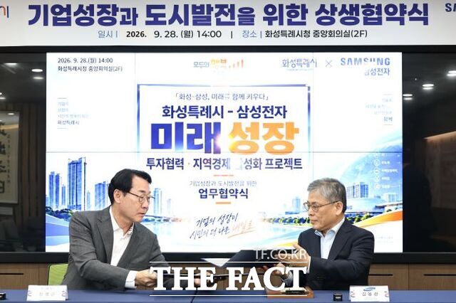 정명근 화성시장(왼쪽)과 김용관 삼성전자 DS부문 경영전략총괄 사장(오른쪽)이 28일 미래성장 상생 협력 업무협약서에 서명한 뒤 협약서를 교환하고 있다. /화성시
