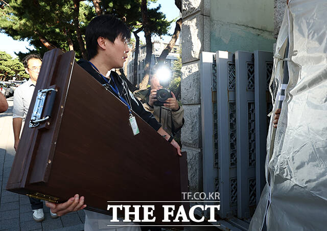 공소청 현판 천막 안으로 옮기는 관계자.