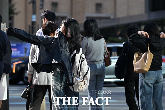 겉옷 걸치고 옷깃 여미는 시민들.